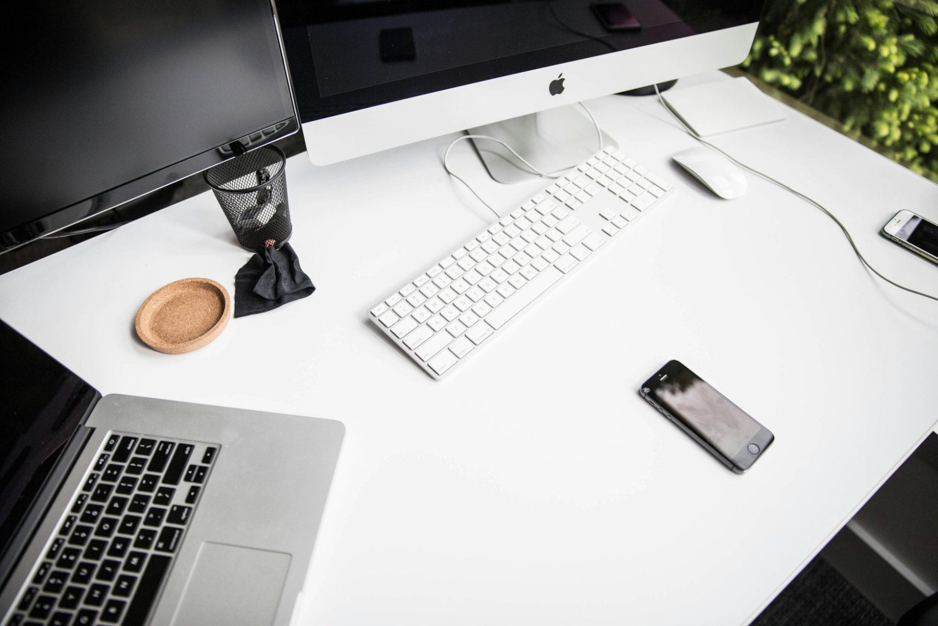 two desktop screens, macbook and cellphone