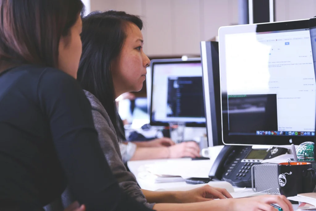 Two office workers collaborating using cloud services securely with full cyber security controls in place
