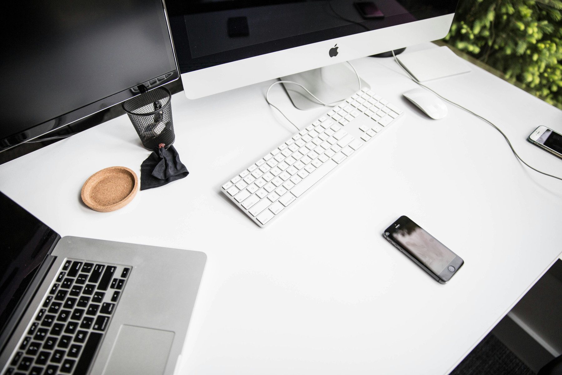 two desktop screens, macbook and cellphone
